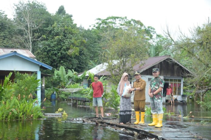 Bupati Sambas, Satono saat menyalurkan bantuan pangan kepada masyarakat terdampak banjir di Desa Tempapan Hulu, Kecamatan Galing, Senin (30/1/2023)/Foto Humas Pemkab Sambas.