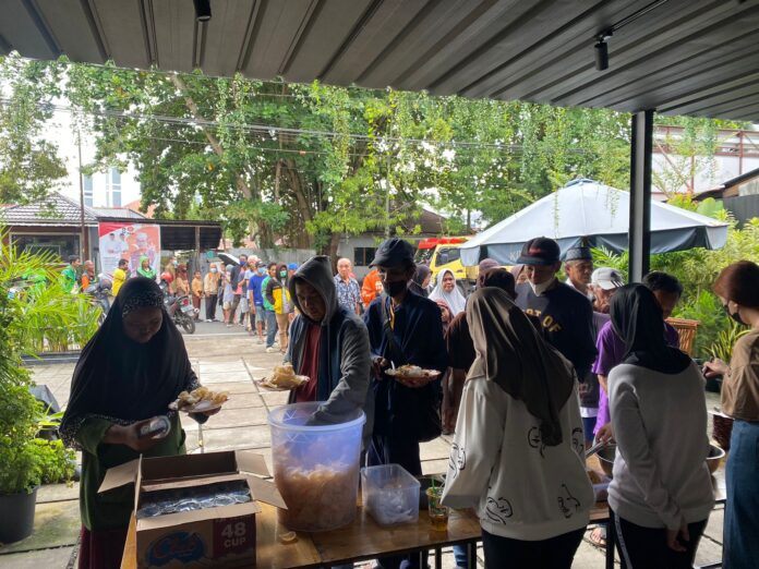 Masyarakat mengatre mengambil makanan gratis yang disediakan oleh warung Kopilojik. Jumat (1/12/2023). (Insidepontianak.com/Ayu)